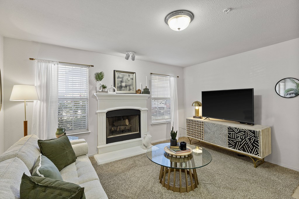 A living room with a fireplace, a couch, a coffee table, and a television.