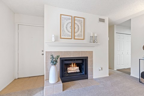 A fireplace with a vase and candles on top of it.