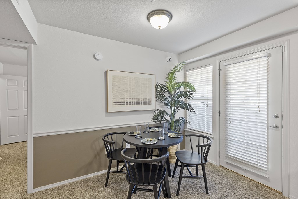 A dining room with a table set for four.