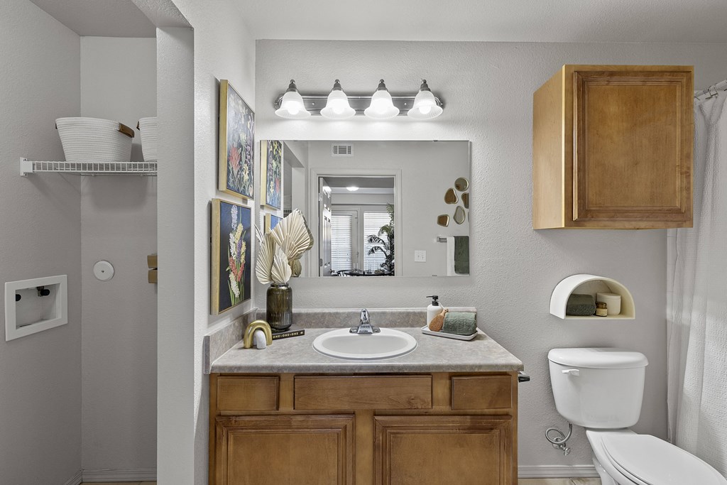 A bathroom with a white toilet and a wooden cabinet.