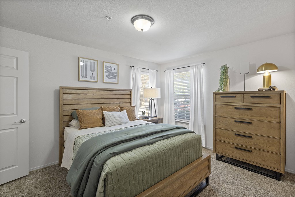 A bedroom with a bed, nightstand, and lamp.