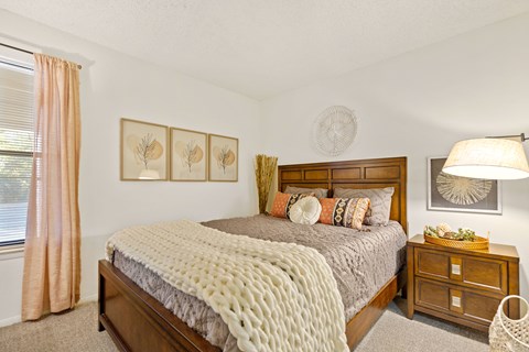 A bedroom with a large bed and a wooden headboard.