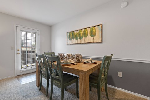 A dining room with a wooden table and chairs.