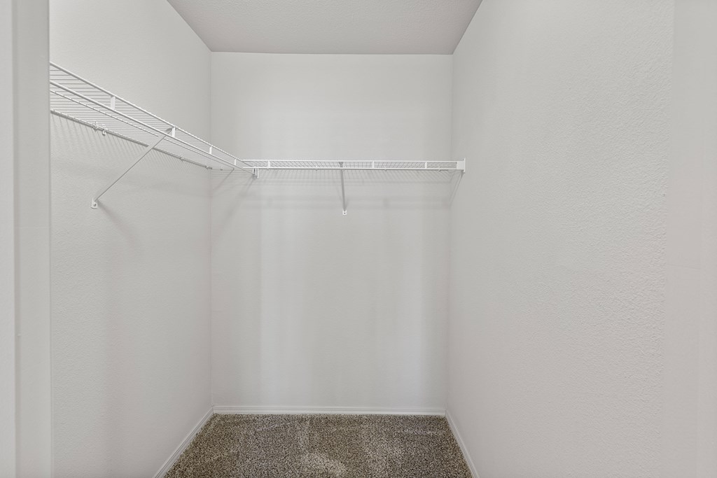 A small, empty room with a carpeted floor and a white wall.