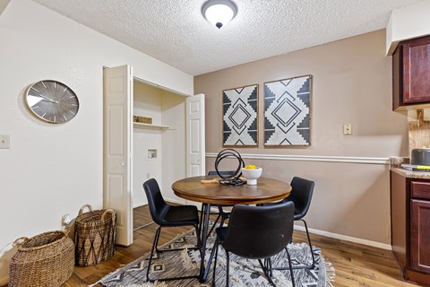 A dining room with a round table and chairs.