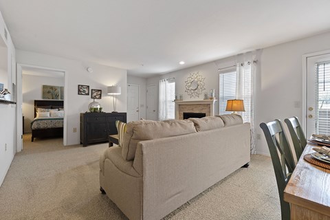 A living room with a beige couch and a fireplace.