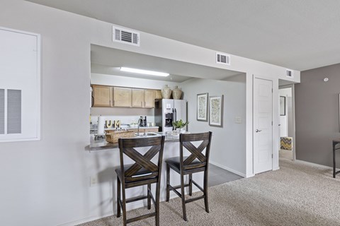 A kitchen area with a table and two chairs.