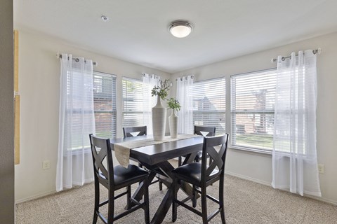 A dining room with a table and chairs.