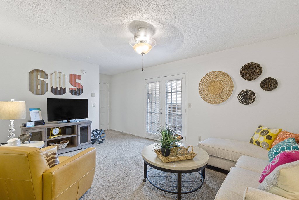 A living room with a yellow couch and a coffee table.