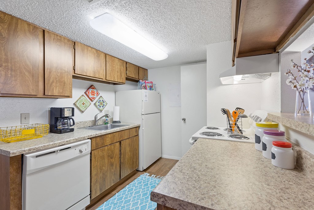 A kitchen with wooden cabinets and white appliances.