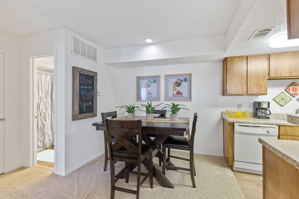 A kitchen with a dining table and chairs.