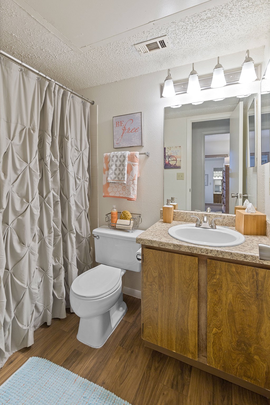 A bathroom with a toilet, sink, and shower curtain.