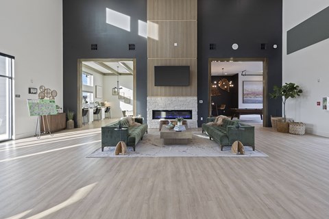 A modern living room with a green couch and a wooden floor.