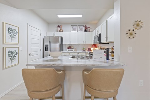 A kitchen with a table and chairs.