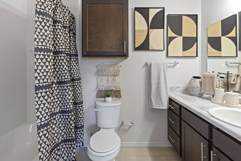 A bathroom with a toilet, sink, and shower curtain.