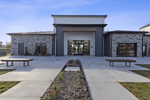 A modern building with a stone facade and a large glass entrance.