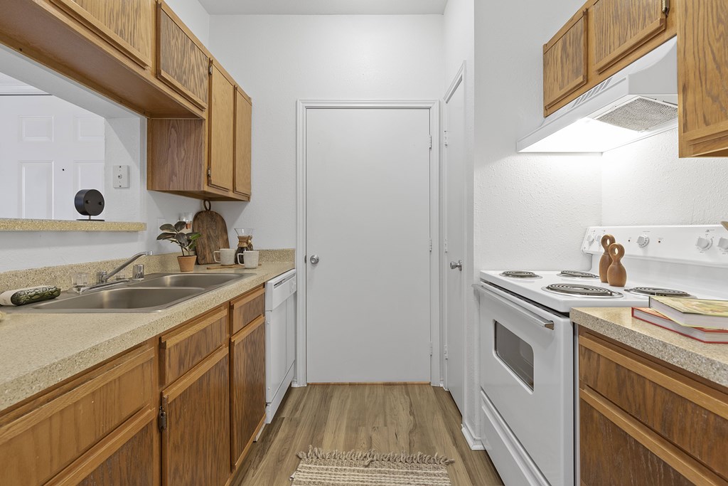 A kitchen with wooden cabinets and a white oven.