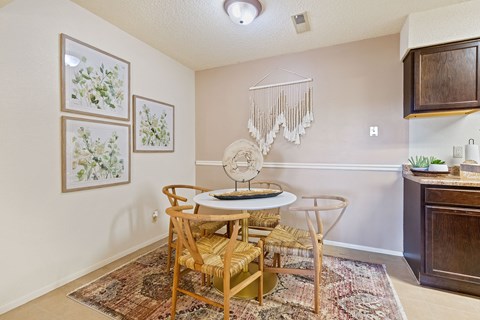 A dining room with a table and chairs.