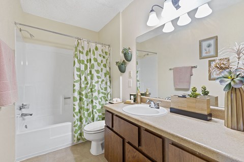 A bathroom with a white tub, sink, and toilet.