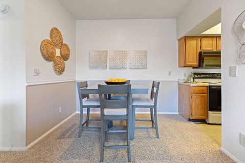 A dining room with a table and chairs.