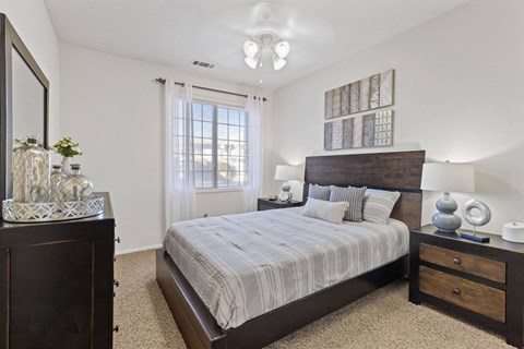 A bedroom with a large bed, a dresser, and a mirror.