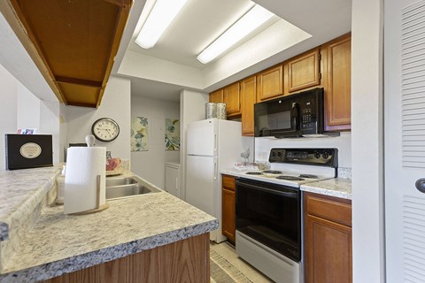 A kitchen with wooden cabinets and a granite countertop.