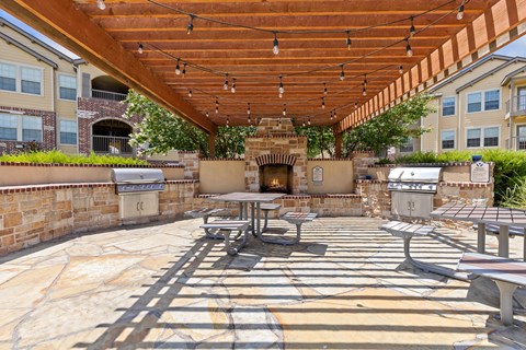A patio with a fireplace and seating area.