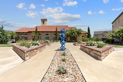 A blue sculpture in the middle of a garden.