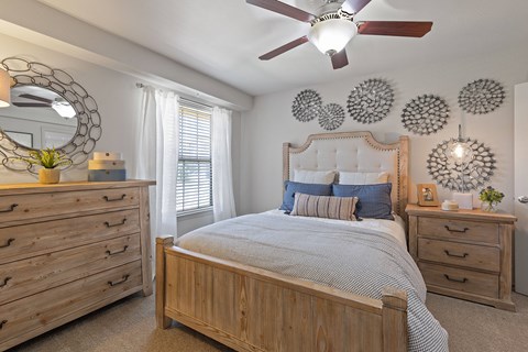 A bedroom with a bed, dresser, and mirror.