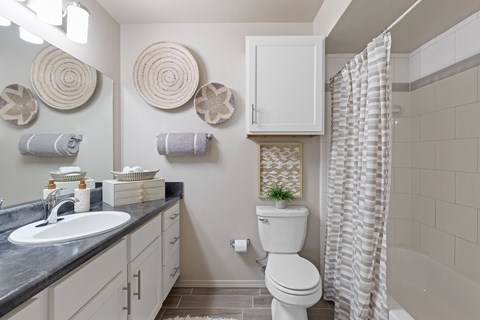 A bathroom with a white toilet, sink, and shower curtain.