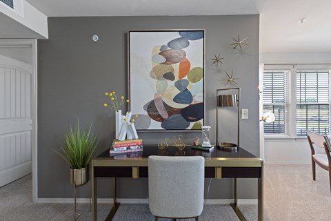 A modern home office with a large abstract painting on the wall.
