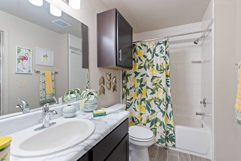 A bathroom with a sink, toilet, and shower.