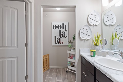 A bathroom with a white sink and a mirror with a white frame.