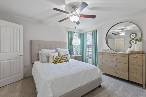 A bedroom with a bed, dresser, and mirror.