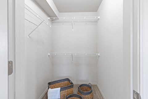 A white closet with a shelf and two baskets.