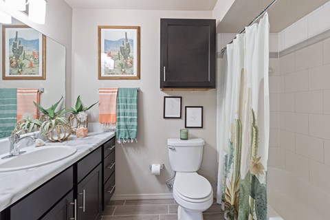 A bathroom with a toilet, sink, and shower.