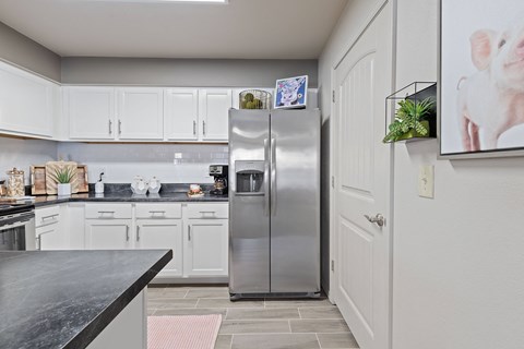 A kitchen with a refrigerator and a counter.