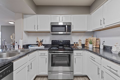 A modern kitchen with white cabinets and stainless steel appliances.