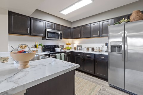 A kitchen with a marble countertop and stainless steel appliances.