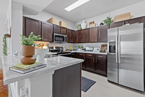 A modern kitchen with dark brown cabinets and a white island.