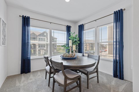 A dining room with a round table and chairs.