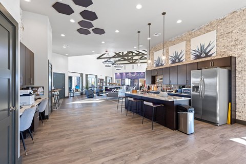 A modern kitchen with a wooden floor and a brick wall.