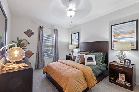 A bedroom with a bed, nightstand, and a picture on the wall.