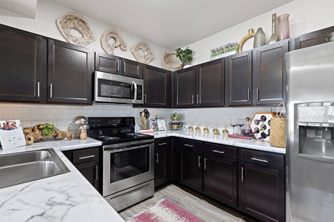 A kitchen with black cabinets and stainless steel appliances.