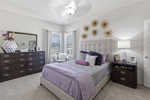 A bedroom with a bed, dresser, and mirror.