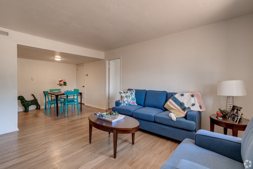 a living room and dining room with a blue couch and a table
