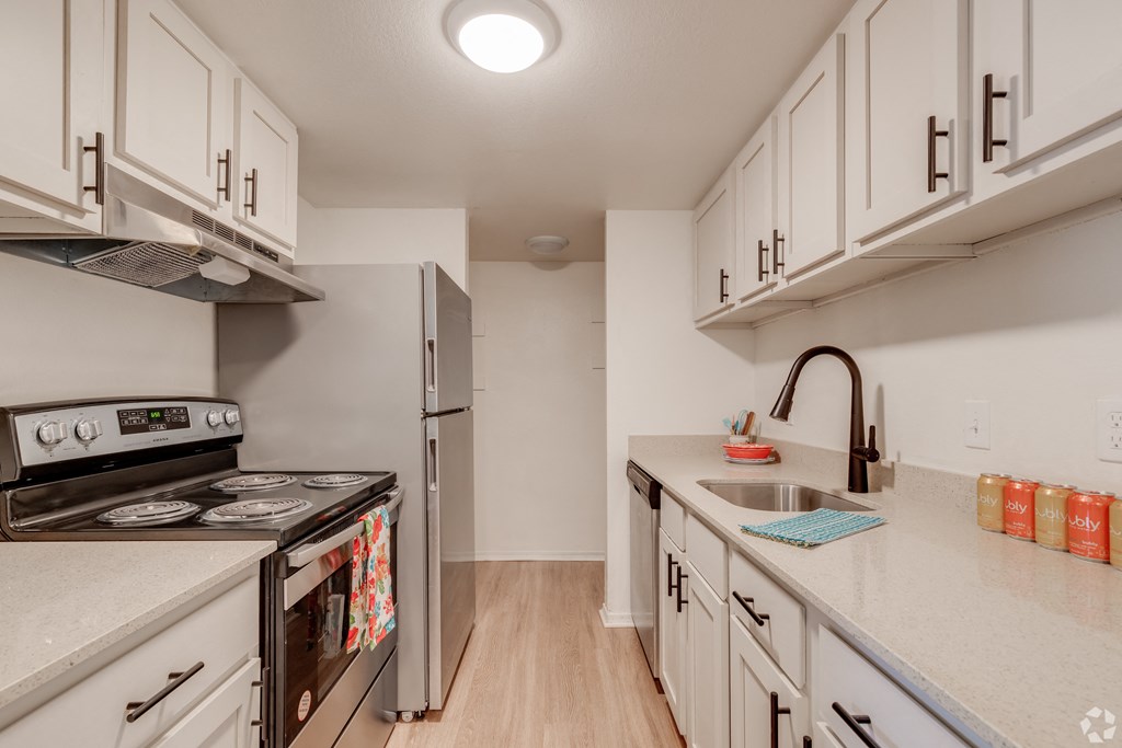 a renovated kitchen with white cabinets and stainless steel appliances