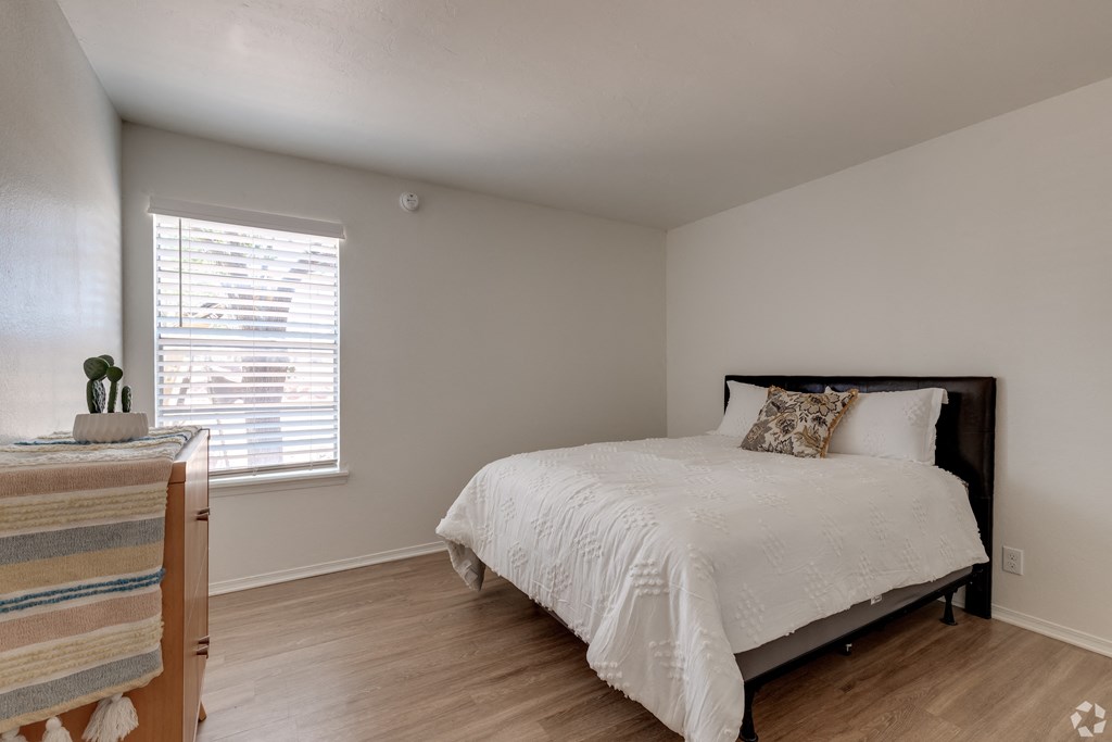 a bedroom with a bed and a dresser and a window