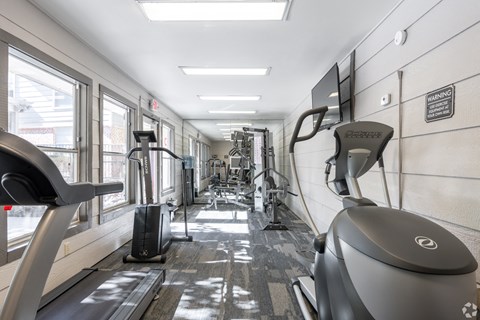 A gym with treadmills, elliptical machines and other exercise equipment.