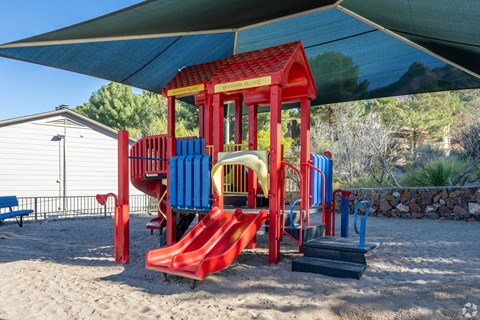 A red and blue playground structure with a red slide.